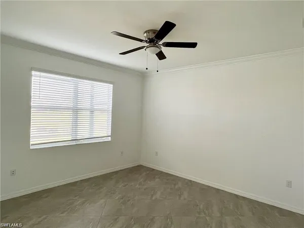 an empty room with a window and a fan