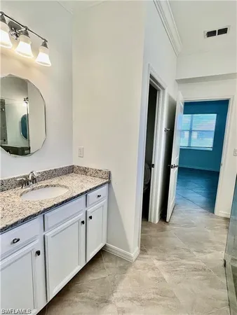 a bathroom with a granite countertop sink and a mirror