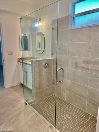 a bathroom with a sink mirror and shower