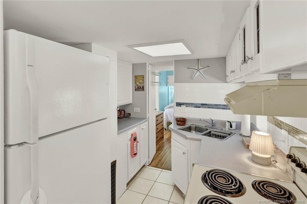 10701 South Ocean Drive, Unit 713 Jensen Beach, FL 34957 - Photo 11 of 39 a kitchen with a refrigerator a stove and wooden floor