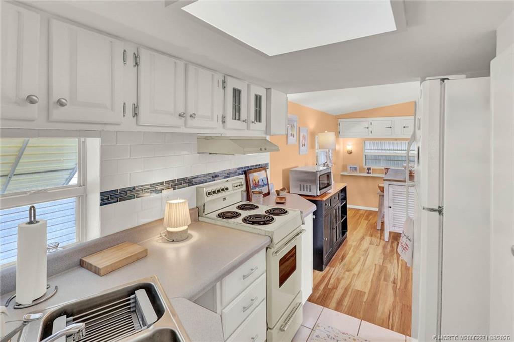 10701 South Ocean Drive, Unit 713 Jensen Beach, FL 34957 - Photo 12 of 39 a kitchen with stainless steel appliances granite countertop a stove and a refrigerator