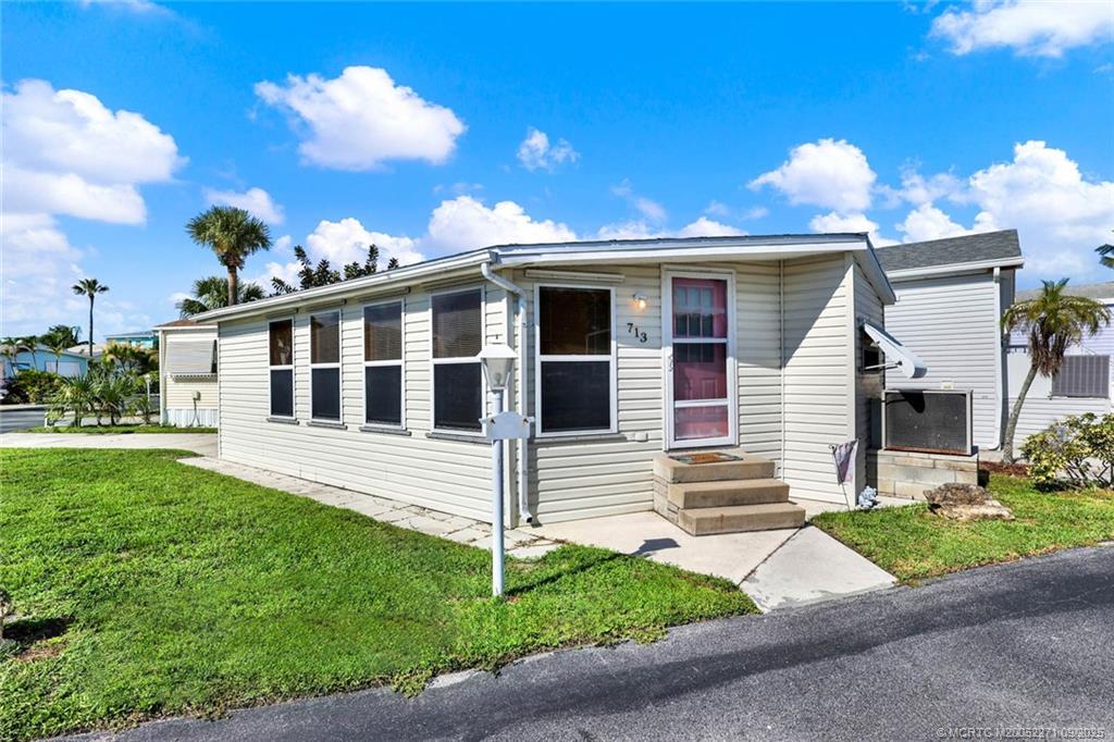 10701 South Ocean Drive, Unit 713 Jensen Beach, FL 34957 - Photo 18 of 39 a front view of a house with a yard