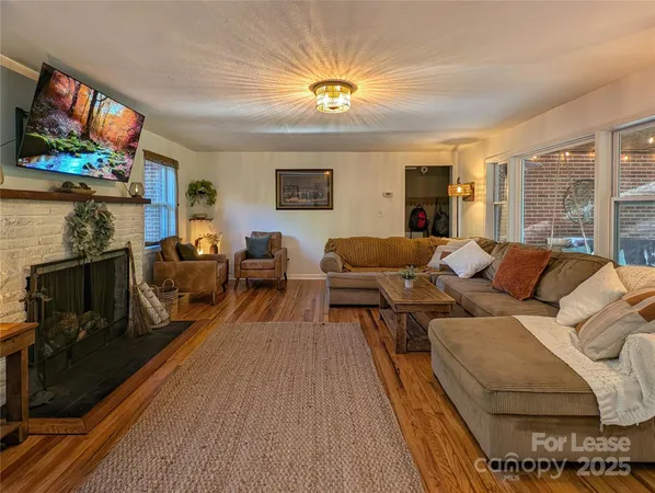 a living room with furniture a flat screen tv and a fireplace