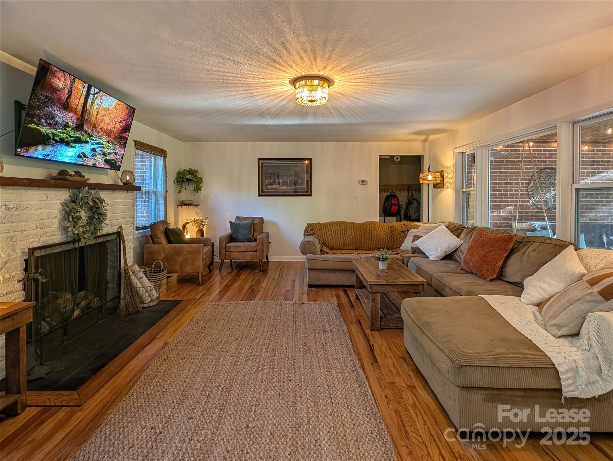 317 Balsam Drive Waynesville, NC 28786 - Photo 11 of 45 a living room with furniture a flat screen tv and a fireplace