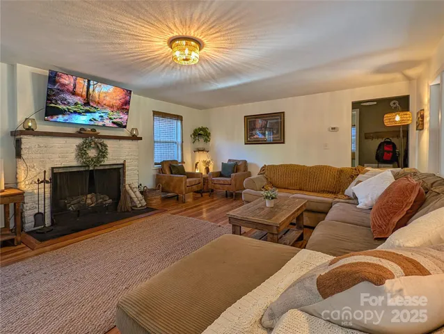 a living room with furniture a flat screen tv and a fireplace