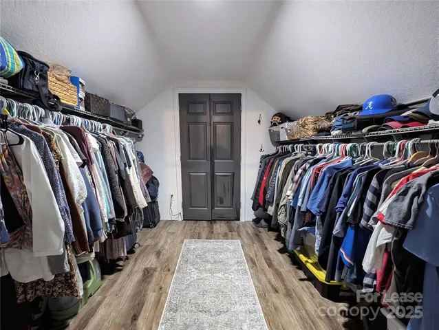 a view of walk in closet with clothes and shoes