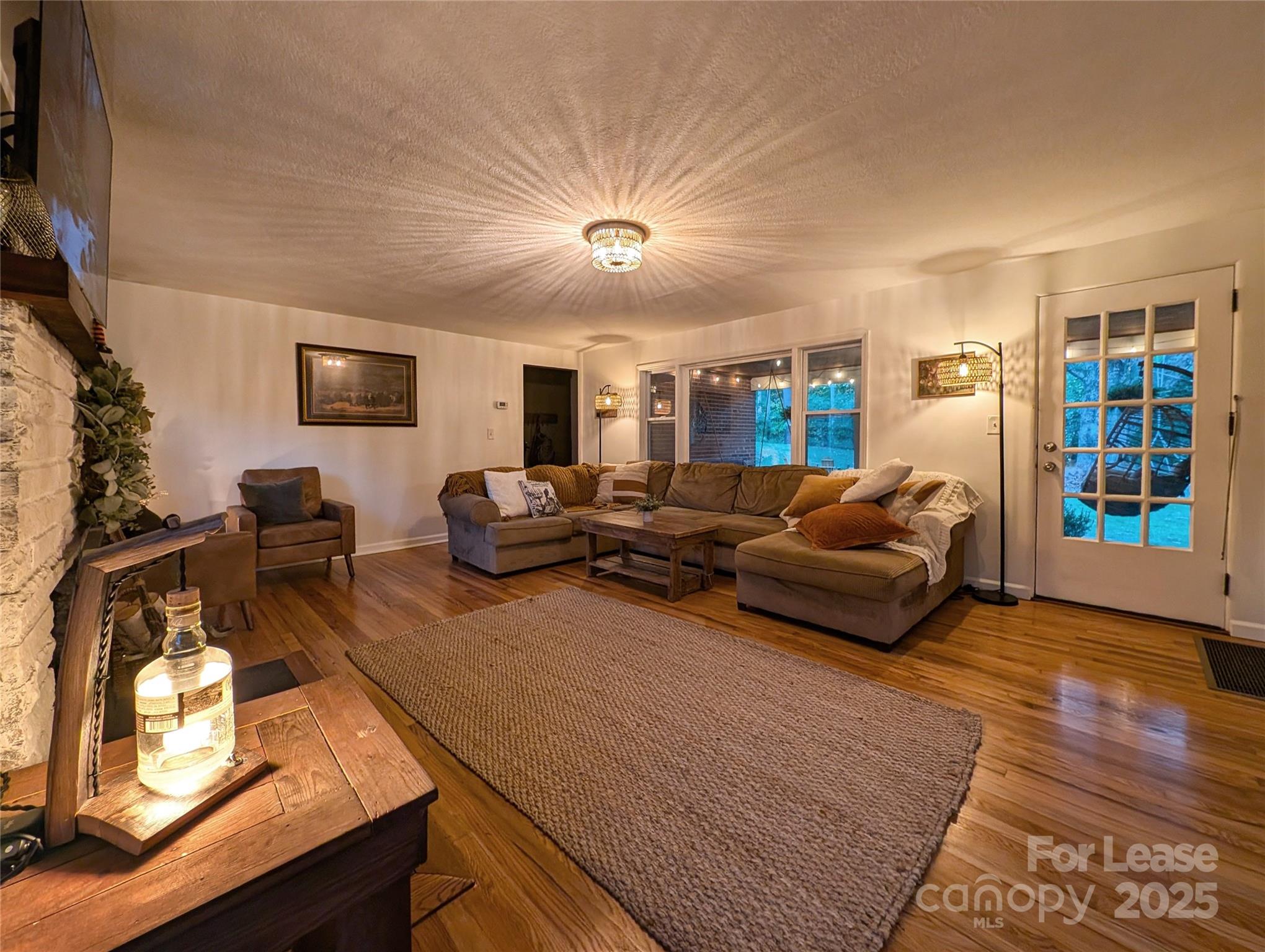 317 Balsam Drive Waynesville, NC 28786 - Photo 33 of 45 a living room with furniture a flat screen tv and a fireplace