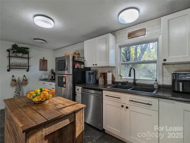 a kitchen with granite countertop stainless steel appliances and wooden cabinets