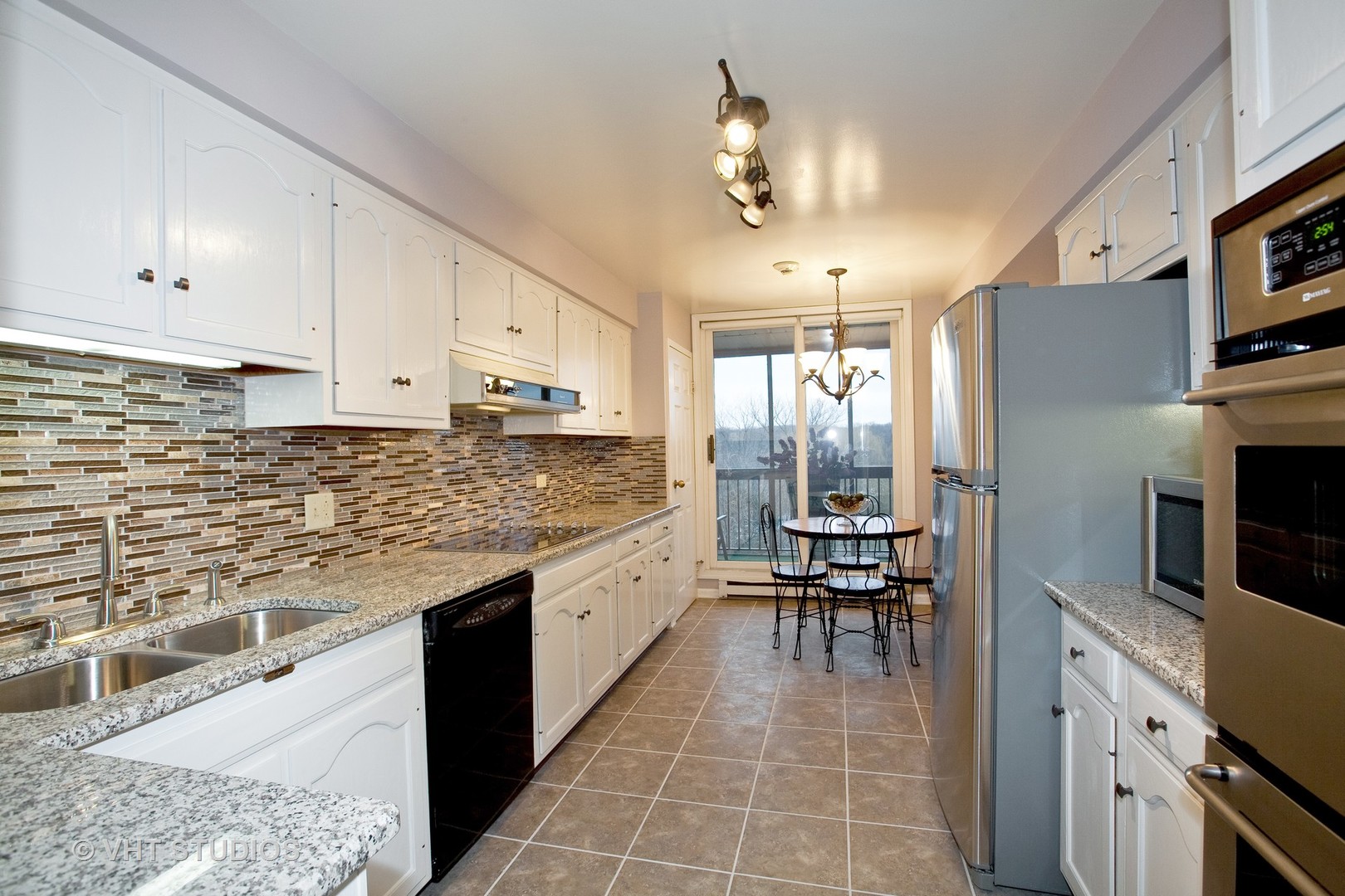 1140 Old Mill Road, Unit 408F Hinsdale, IL 60521 - Photo 3 of 11 a kitchen with stainless steel appliances granite countertop a stove refrigerator and cabinets