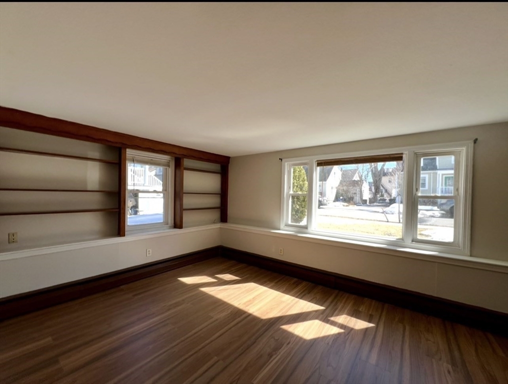 10 Edgemere Road Quincy, MA 02169 - Photo 8 of 25 a view of an empty room with a window and wooden floor