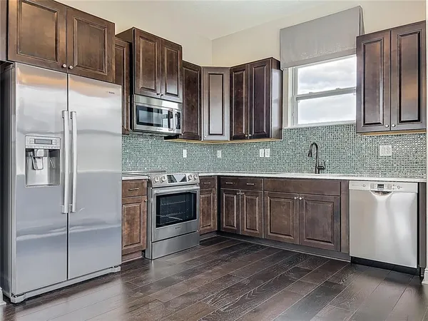 a kitchen with stainless steel appliances granite countertop a refrigerator and a sink