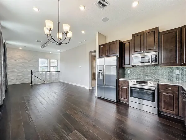 a kitchen with stainless steel appliances granite countertop a stove refrigerator and wooden floor