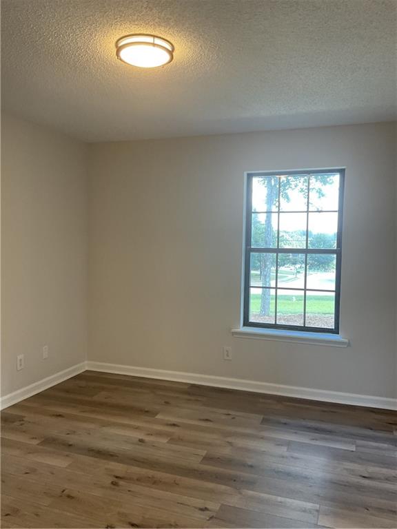 2452 Kilgore Road Buford, GA 30519 - Photo 14 of 16 a view of an empty room with wooden floor and a window