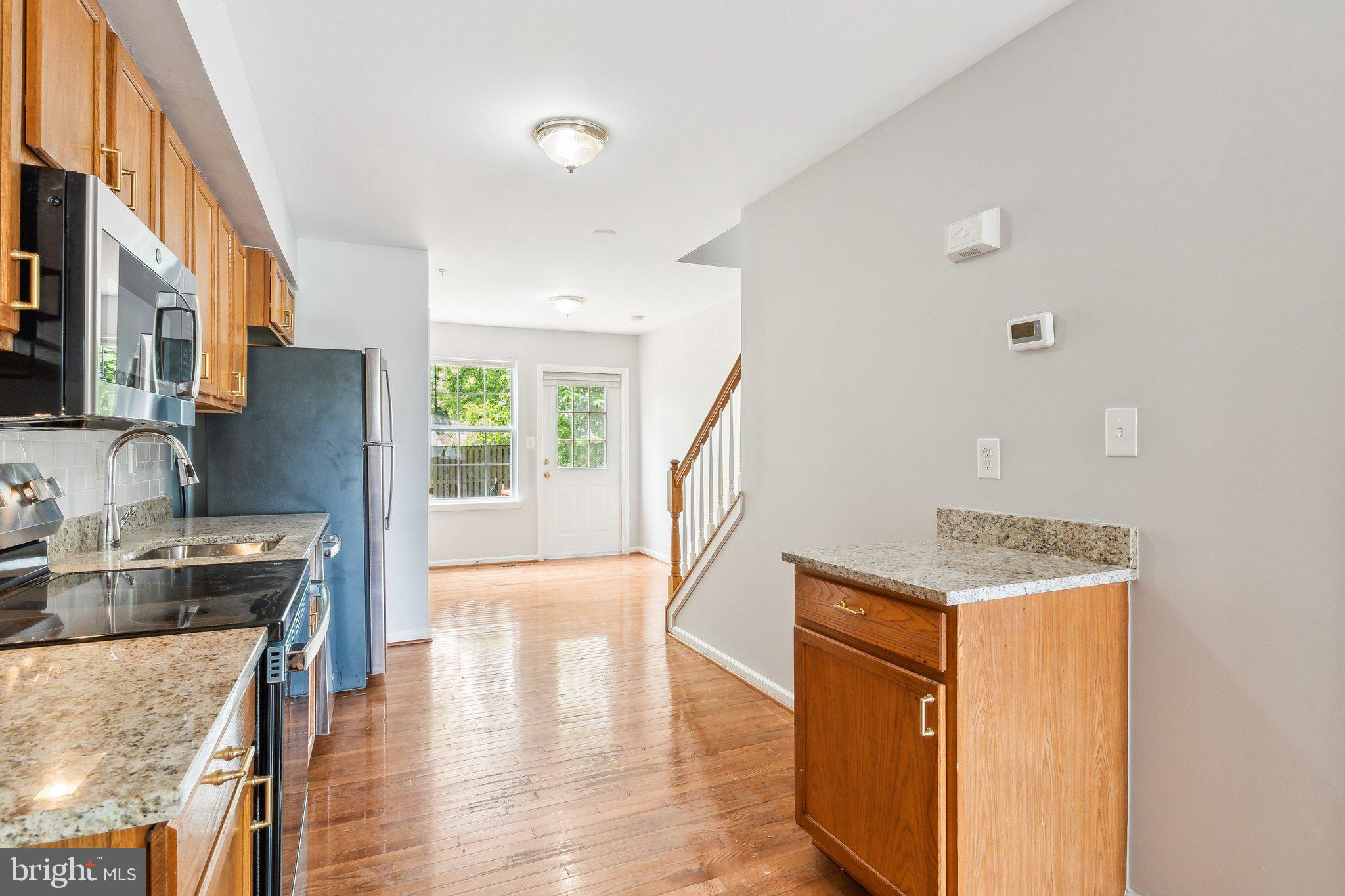 28 Johnson Place Annapolis, MD 21401 - Photo 22 of 35 a hallway with kitchen island stainless steel appliances wooden floor and living room view