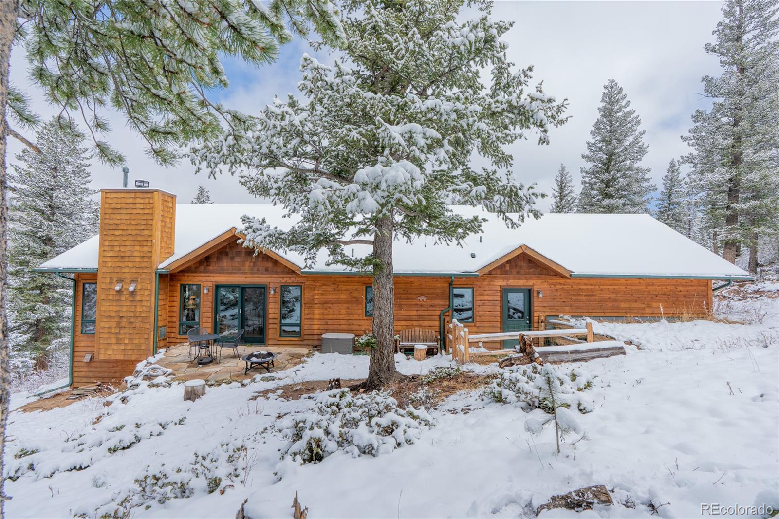 2147 McGraw Ranch Road Estes Park, CO 80517 - Photo 13 of 26 a front view of a house with a yard covered with snow and trees