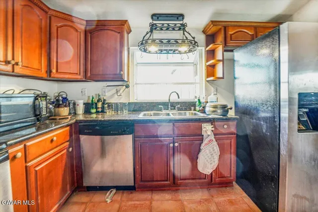 a kitchen with granite countertop cabinets stainless steel appliances and a sink