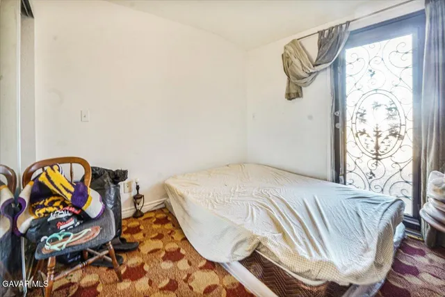 a bedroom with a large bed and a chandelier