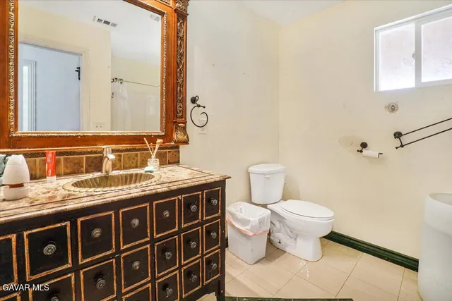 a view of a hallway with wooden floor and a bathroom