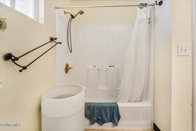 a view of a hallway with wooden floor and a bathroom