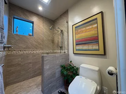 a bathroom with a toilet a sink and mirror