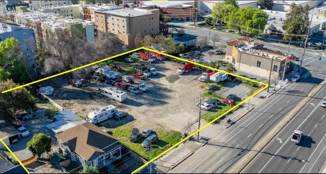 a view of a street with cars parked on the road
