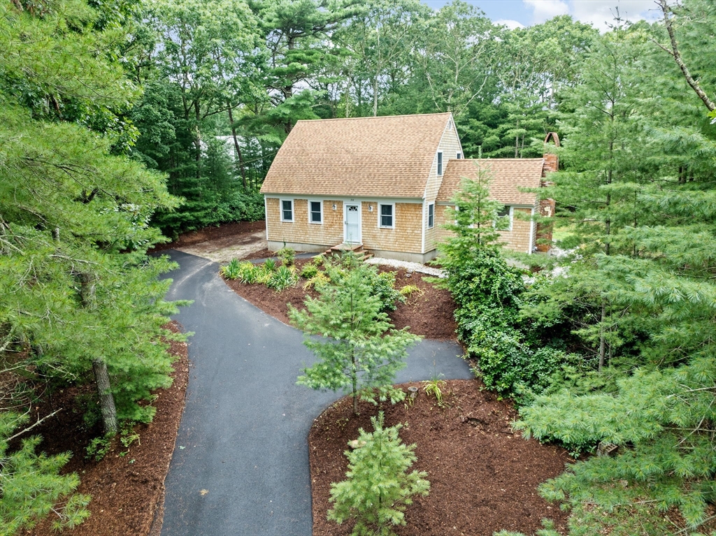 an aerial view of a house with a yard and large trees