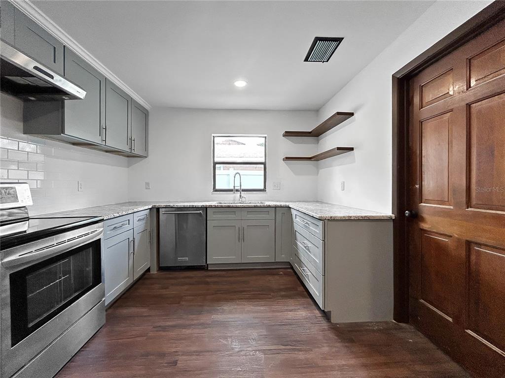 4545 Debbie Lane Lutz, FL 33559 - Photo 11 of 25 a kitchen with granite countertop a sink cabinets and stainless steel appliances