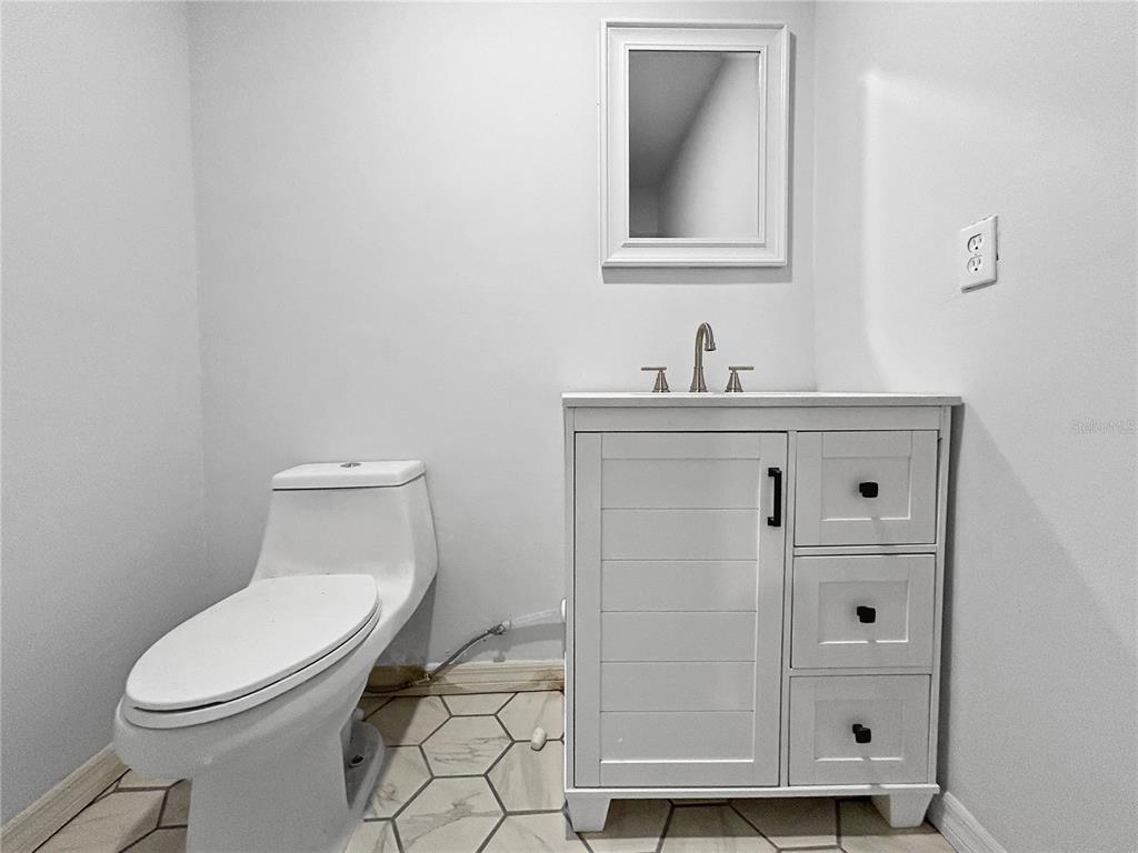 4545 Debbie Lane Lutz, FL 33559 - Photo 20 of 25 a bathroom with a toilet a sink a vanity and mirror