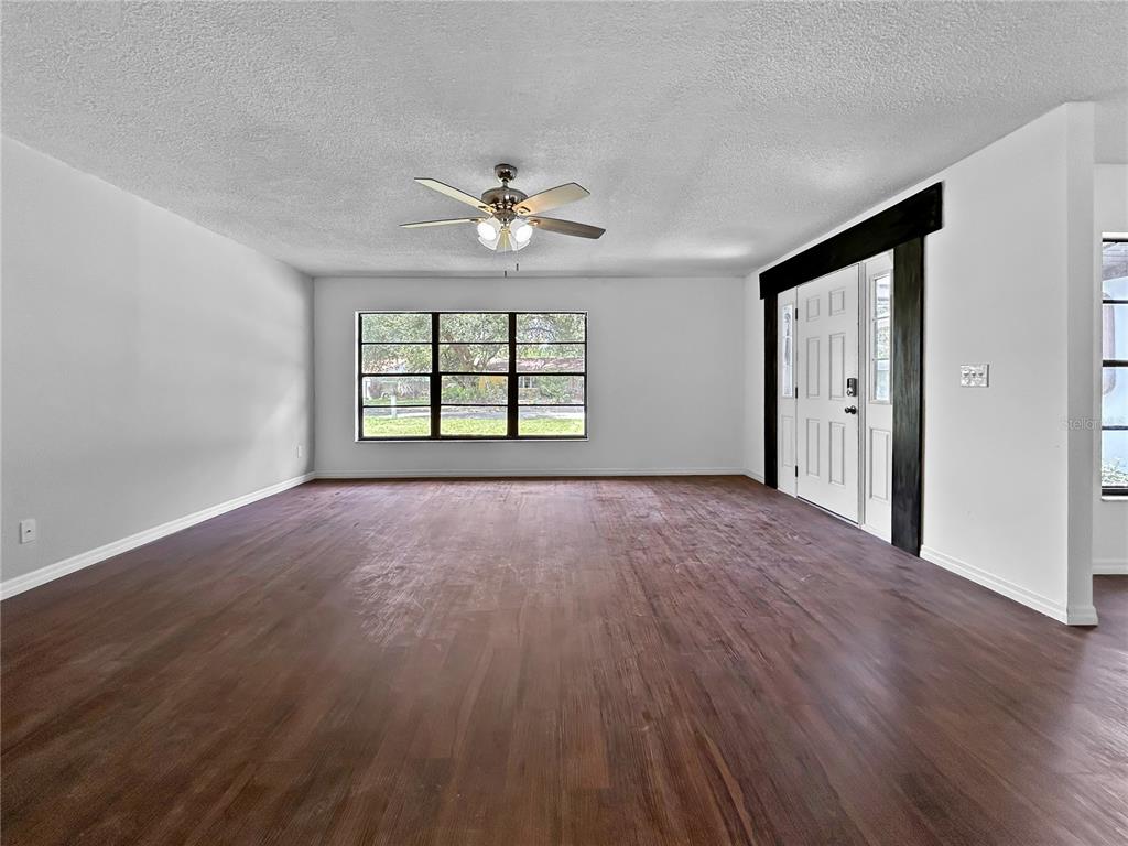 4545 Debbie Lane Lutz, FL 33559 - Photo 4 of 25 a view of an empty room with a window and wooden floor