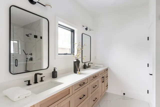 a bathroom with double vanity sink and mirror