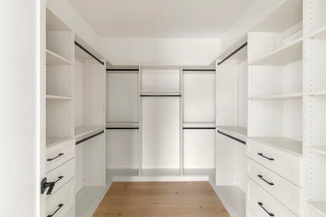 a view of walk in closet with empty racks