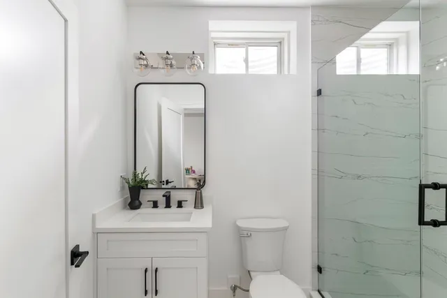 a bathroom with a sink a toilet and mirror