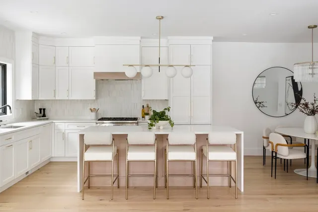 a kitchen with a dining table chairs and white cabinets