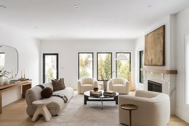 a living room with furniture fireplace and a large window