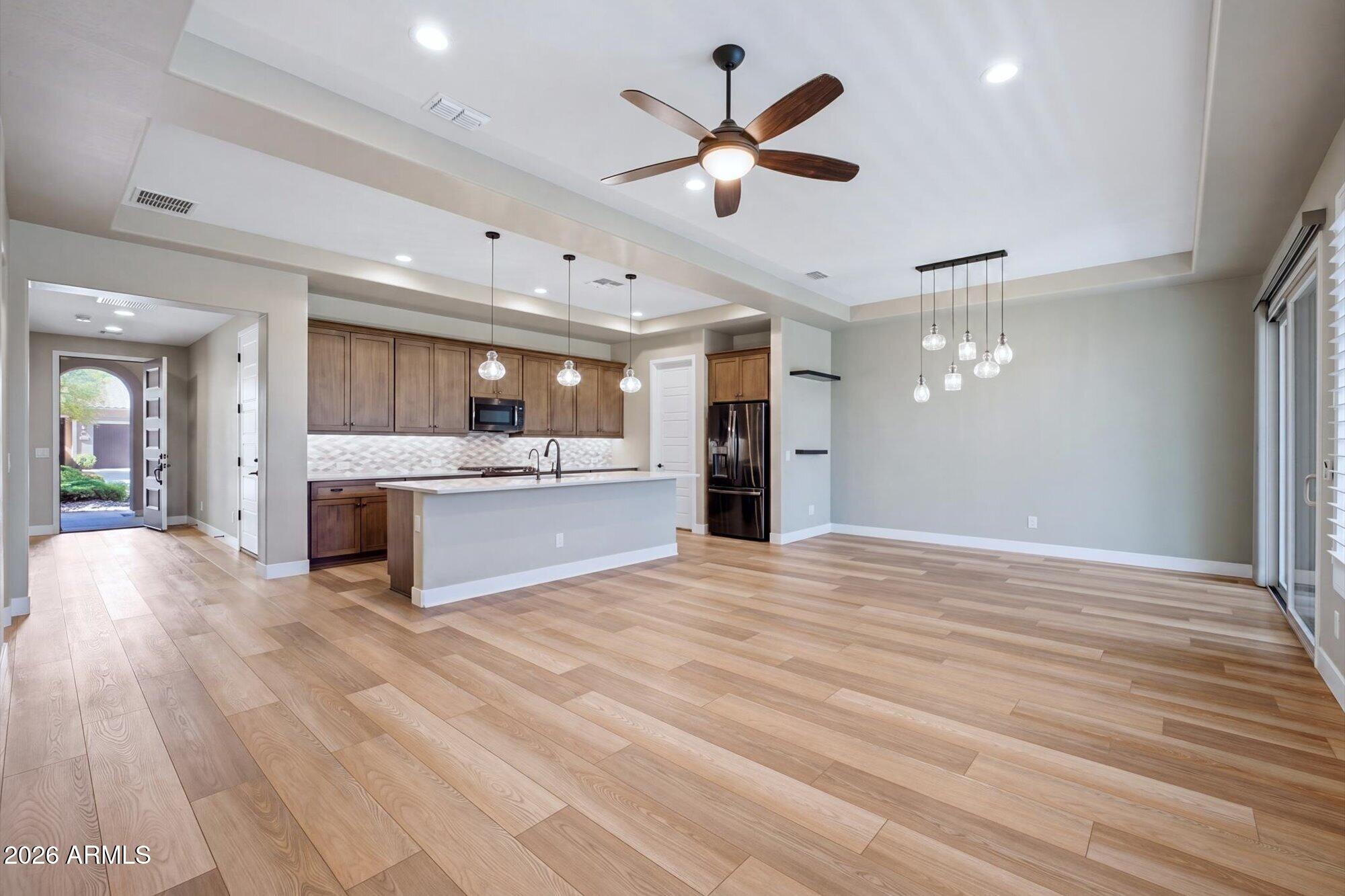 16849 West Merrell Street Goodyear, AZ 85395 - Photo 5 of 35 a view of a kitchen with a sink dishwasher a kitchen with a stove and wooden floor
