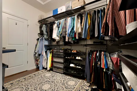 a view of walk in closet with clothes and shoes