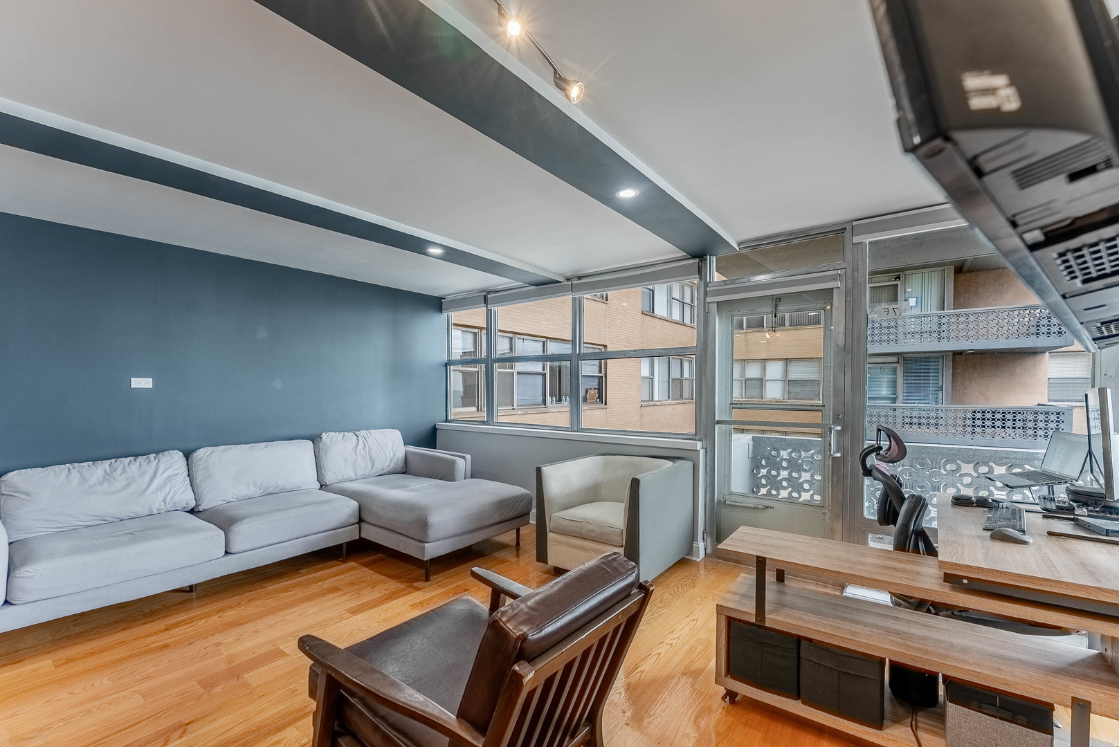6301 North Sheridan Road, Unit 7F Chicago, IL 60660 - Photo 3 of 15 a living room with furniture a flat screen tv and a floor to ceiling window