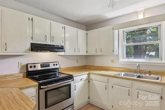 a kitchen with granite countertop white cabinets and appliances
