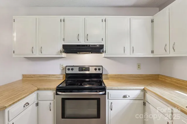 a kitchen with white cabinets and appliances