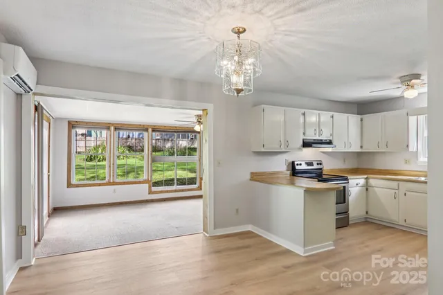 a kitchen with stainless steel appliances granite countertop a stove top oven a sink and a refrigerator