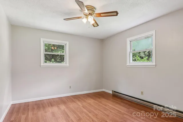 a view of empty room with wooden floor