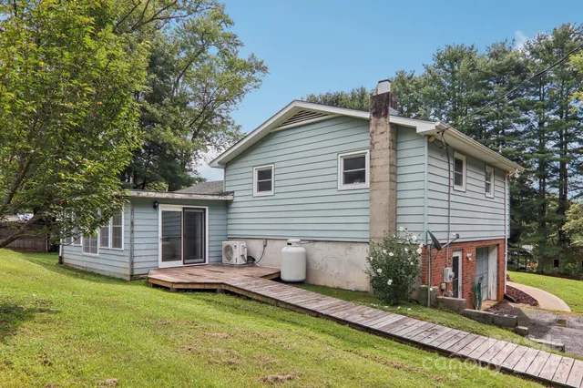 a view of a house with backyard and chairs