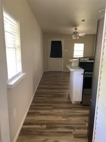 a kitchen with stainless steel appliances granite countertop a sink cabinets and wooden floor