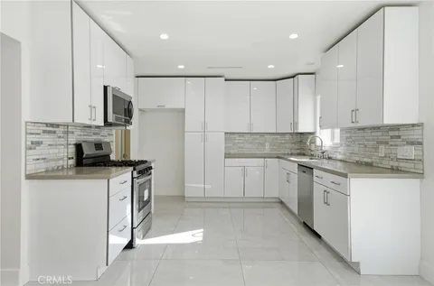 a kitchen with stainless steel appliances granite countertop a stove a sink and a refrigerator