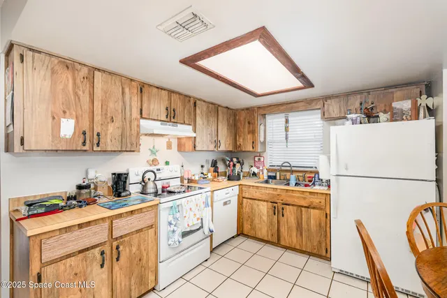 a kitchen with a sink a refrigerator and cabinets