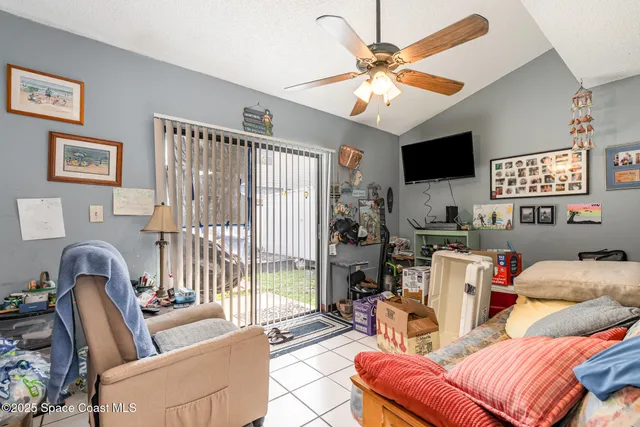a living room with furniture a ceiling fan and a flat screen tv