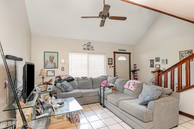 a living room with furniture ceiling fan and a window