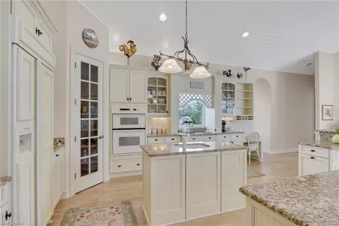 a large kitchen with stainless steel appliances granite countertop a lot of counter space and wooden floor