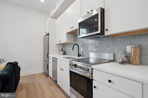 a kitchen with stainless steel appliances a sink a stove and microwave