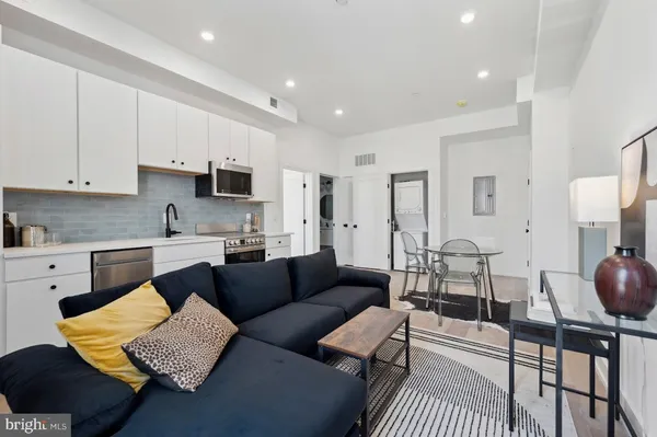 a living room with furniture and a view of kitchen